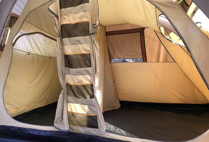 View into the sleeping rooms with their zippered windows. Observe multiple storage elements between the doors.